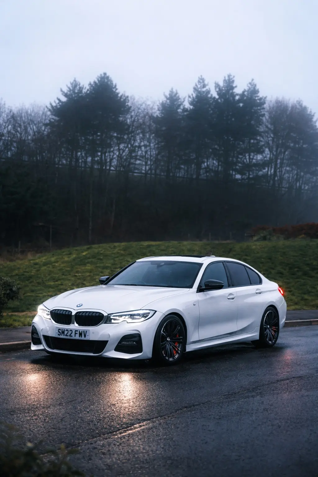 White BMW photographed on a wet road