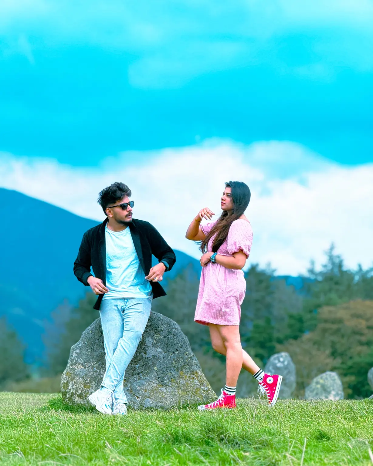 Couple posing in front of misty hills